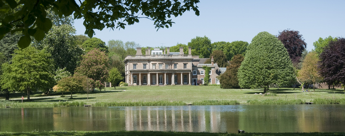 A view of Riseholme Old Hall from across a lake
