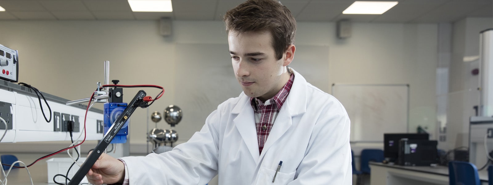 Male student working on a mechanical devise in a laboratory