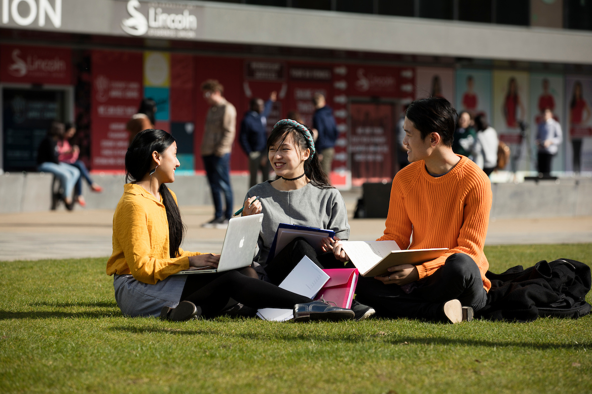 Students sitting with a laptop