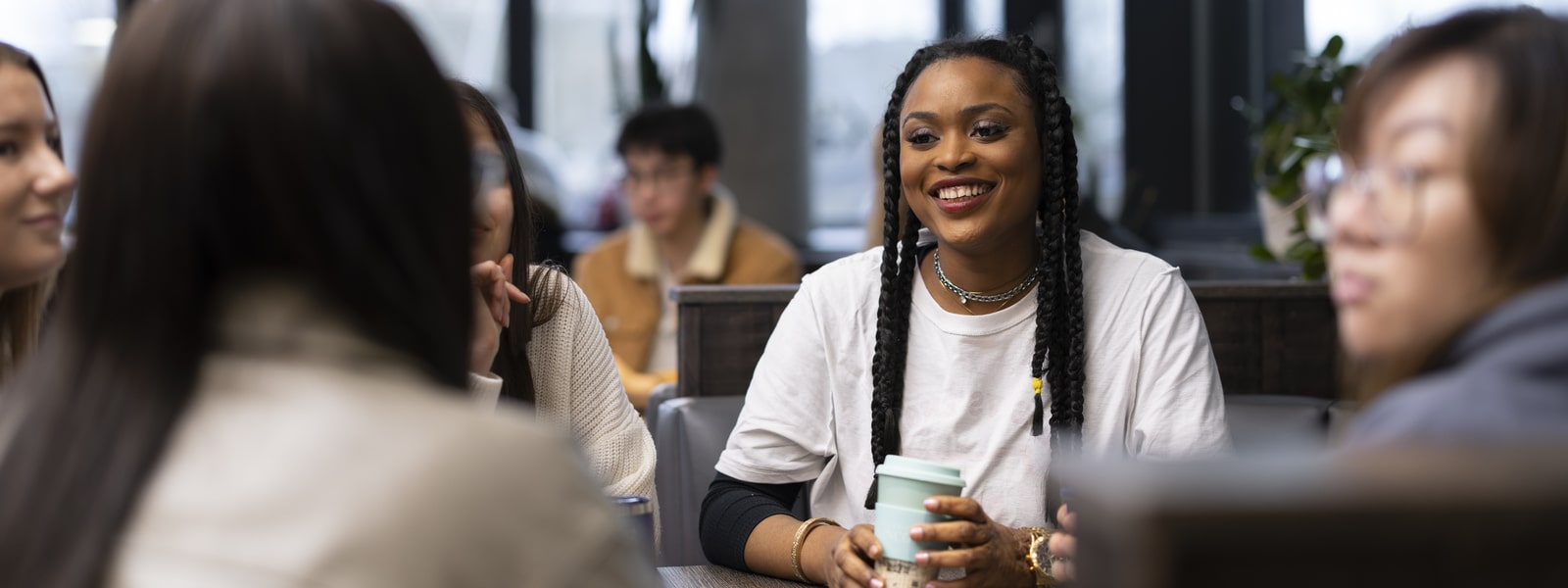 A student enjoying a hot drink with friends