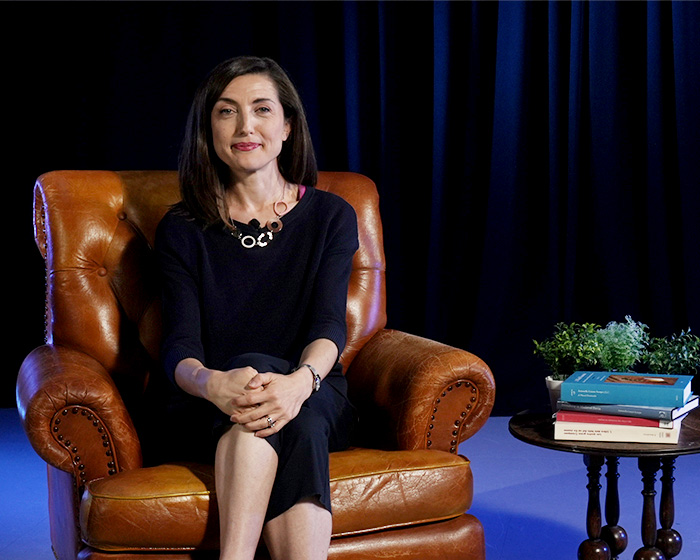 A woman sat in a brown armchair